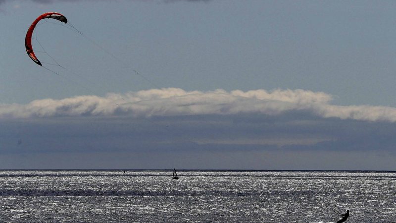 A kite surfer makes the most of weather conditions on Dollymount strand in Dublin, Ireland, Sunday June 30, 2019. Northern Europe is sweltering in hot sunny weather with predictions that the conditions will continue for the coming days.(Brian Lawless/PA via AP)