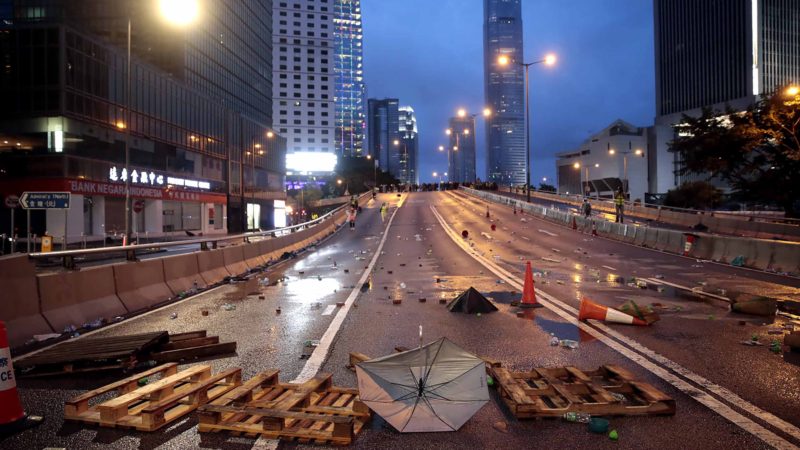 A street lies littered with objects hurled between protestors and policemen in Hong Kong, Saturday, Aug. 31, 2019. Hong Kong police fired blue-colored water from water cannons and tear gas on Saturday in a standoff with protesters outside government headquarters. (AP Photo/Jae C. Hong)