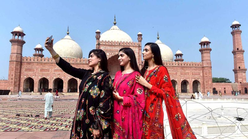 Muslim women take selfie pictures after offering Eid al-Adha prayers at the Badshahi Mosque in Lahore on August 12, 2019. - Muslims around the world are celebrating Eid al-Adha (the feast of sacrifice), the second of two Islamic holidays celebrated worldwide marking the end of the annual pilgrimage or Hajj to the Saudi holy city of Mecca. (Photo by ARIF ALI / AFP)