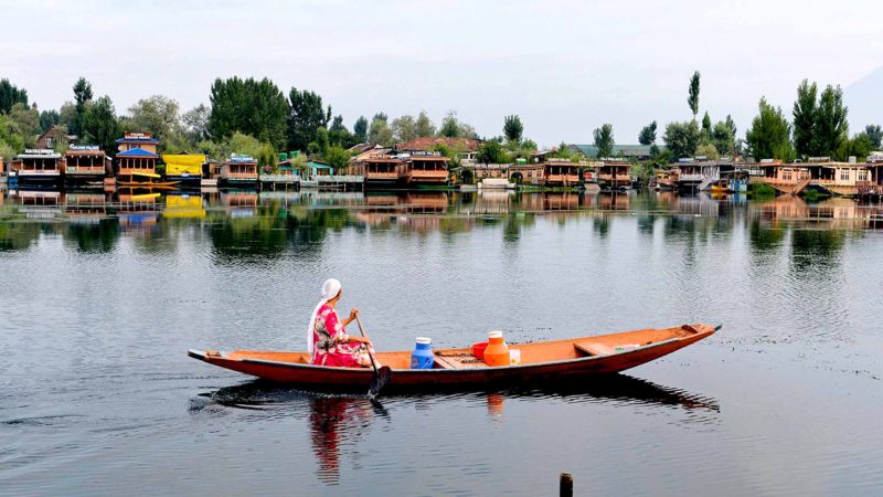 In this picture taken on August 13, 2019 a woman paddles a small boat on the Dal Lake during security lockdown in Srinagar on August 13, 2019, after the Indian government stripped Jammu and Kashmir of its autonomy. (Photo by Sajjad  HUSSAIN / AFP)