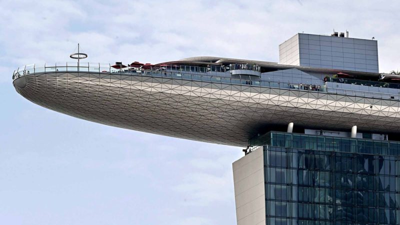 TOPSHOT - Visitors stand on the roof deck of the Marina Bay Sands Skypark in Singapore on August 29, 2019.  AFP/RSS.