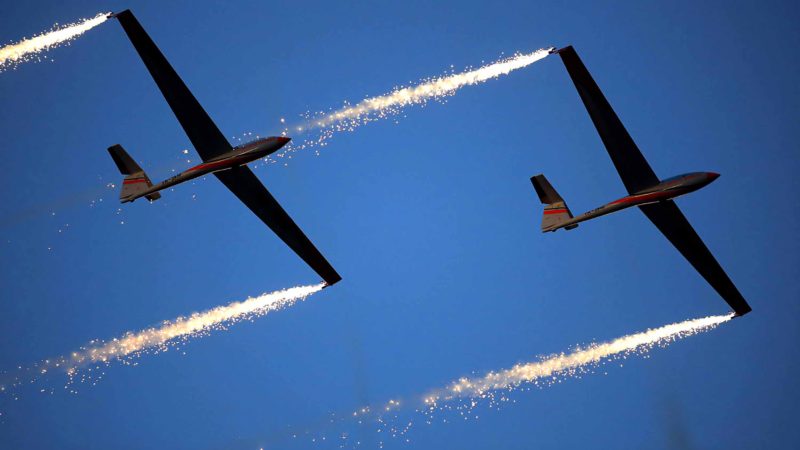 In this picture taken on Sunday, Aug. 25, 2019, gliders with pyrotechnics attached to their wings fly during an international air show in Bucharest, Romania. Thousands of Romanians took to an airfield on the edge of the capital Bucharest for a display of aerobatics and air power by pilots and aircraft from several countries.(AP Photo/Vadim Ghirda)