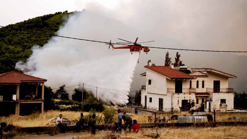 (190813) -- EVIA ISLAND (GREECE), Aug. 13, 2019 (Xinhua) -- A water-dropping helicopter is seen battling a wildfire near Makrymalli village on Evia island, Greece, on Aug. 13, 2019. Greek firefighters battled the largest wildfires of this summer raging in two major fronts near Athens on Tuesday, local authorities said. More than 500 residents have been evacuated from three villages as a precautionary measure, according to the Fire Service. (Photo by Nick Paleologos/Xinhua)