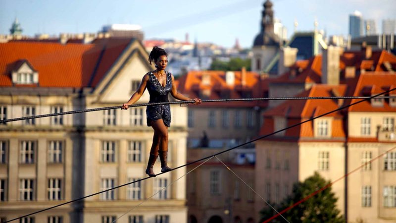 (190814) -- PRAGUE, Aug. 14, 2019 (Xinhua) -- French rope walker Tatiana-Mosio Bongonga walks on a rope in Prague, the Czech Republic, on Aug. 14, 2019. Tatiana-Mosio Bongonga from the French troup Cie Basinga Wednesday crossed the Vltava River on a 350-meter-long rope at the height of 35 meters in Prague. She crossed the river without any visible protection, using a four-metre-long balance pole weighing 12 kg. The whole journey took her about 40 minutes. (Photo by Dana Kesnerova/Xinhua)