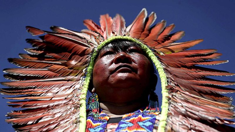 In tis Aug. 13, 2019 photo, a female indigenous chief attends a march by indigenous women protesting the policies of Brazilian President Jair Bolsonaro in Brasilia, Brazil. Since taking office in January, the administration of Bolsonaro has consistently clashed with environmentalists and others over possibly opening up the Amazon rainforest to development and agribusiness. Recent data has also pointed to a surge in deforestation, which frequently occurs on indigenous reserves. (AP Photo/Eraldo Peres)