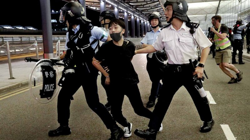 Policemen arrest a protester during a clash at the Airport in Hong Kong, Tuesday, Aug. 13, 2019. Riot police clashed with pro-democracy protesters at Hong Kong's airport late Tuesday night, a chaotic end to a second day of demonstrations that caused mass flight cancellations at the Chinese city's busy transport hub. (AP Photo/Vincent Yu)