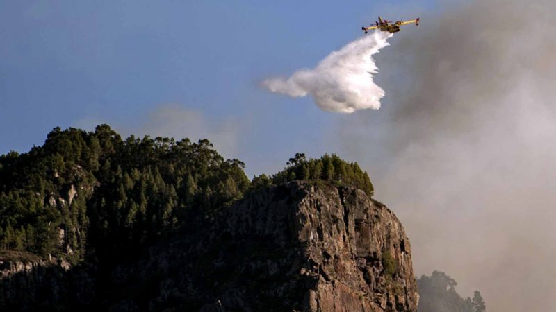 A hydroplane operates on a wildfire in Canary Islands, Spain, Tuesday, Aug. 20, 2019. The wind dropped in the Canary Islands Tuesday, allowing firefighters to make progress against Spain's biggest wildfire so far this year and raising the possibility some evacuated residents may soon be able to return home. (AP Photo/Arturo Jimenez)