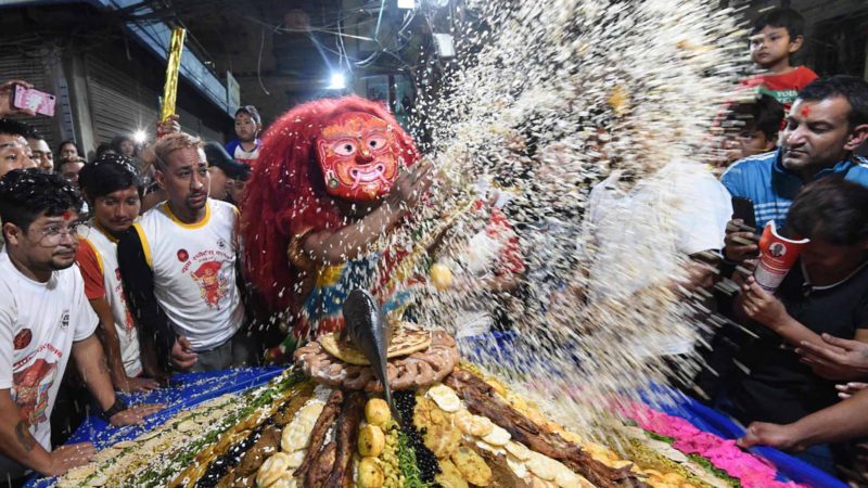 A Nepali traditional masked "Lakhe" dancer receives "Samyabaji" on the fifth day of the "Indra Jatra" festival in Kathmandu on September 15, 2019. - Nepal's week-long festival celebrates 'Indra', the king of gods and the god of rains. Every September, the living goddess is carried on a palanquin in a religious procession through parts of the Nepalese capital. Photo/RSS