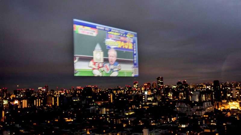 TOPSHOT - A television screen reflected in the window of a high-rise building in the Aoyama area of Tokyo on September 19, 2019 shows a current affairs program depicting Britain's Prime Minister Boris Johnson (R) as a rugby player taking on parliament (L). AFP/RSS.