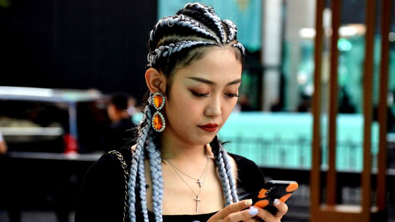 This photo taken on September 19, 2019 shows online fashion influencer Wang Rui wearing a Tiffany necklace using her smart phone in Shanghai. AFP/RSS.