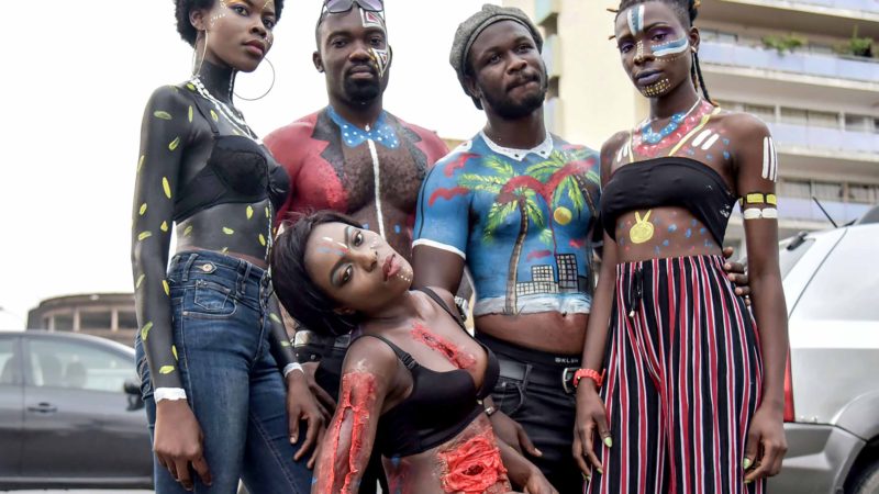 Models pose for a photograph during a "Maquill Art" fashion show on a street in Abidjan on September 5, 2019. - "Make-up is not only about passing pencil and lipstick": the first artistic make-up festival in Cote d'Ivoire wants to break preconceived ideas and popularize a previously unknown profession. AFP/RSS