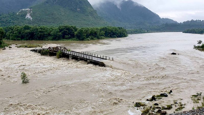 सोमबार रातिदेखि परेको निरन्तर वर्षाले डुबानमा परेको तनहुँको शुक्लागण्डकी नगरपालिका–४ र ८ जोडने सेतीनदीमाथिको पुल । सेतीनदीले पुल डुबाएसँगै उक्त पुल जोखिममा परेको छ । तस्वीर : कृष्ण न्यौपाने