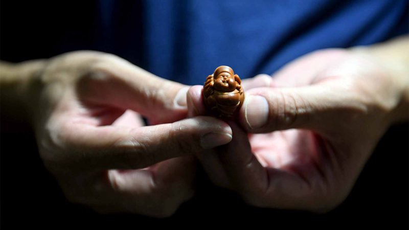 CHANGSHA -- Ma Luocheng displays his fruit pit carving work in Changsha, central China's Hunan Province, Sept. 18, 2019. Ma started learning the fruit pit carving at 21 years old under the guidance of renowned craftsman Zhou Jianming, an inheritor of the national intangible cultural heritage Guangfu fruit pit carving, and has become an outstanding craftsman himself with his award-winning works after years of hard work. Xinhua/RSS.