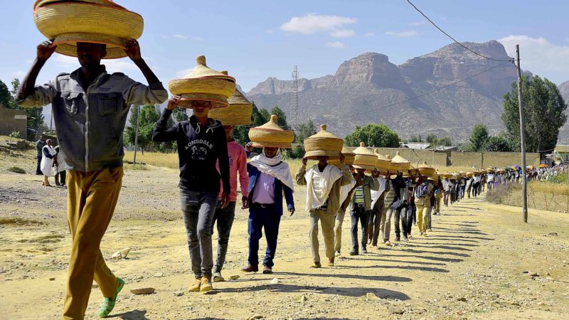 Ethiopian men carry traditional hand-woven food baskets on their heads as they walk ceremoniusly to a reconciliation meeting in the Irob district in northern Ethiopia near the border with Eritrea, near Adigrat, on October 23, 2019. - Residents of Ethiopia's northernmost villages complain that there has been no progress on demarcating the two countries' 1,000-kilometre shared border. 
These problems touch nearly everyone living in cities and towns nestled among the steep escarpments of Ethiopia's northern Tigray region -- the area most affected by the 1998-2000 border war and the long, bitter stalemate that followed. (Photo by MICHAEL TEWELDE / AFP)