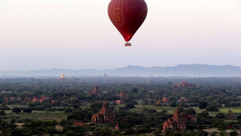 A hot air balloon flies over the Myanmar's ancient temples just before sunrise in old Bagan, Nyaung U district, central Myanmar, Thursday, Oct. 31, 2019. (AP Photo/Aung Shine Oo)