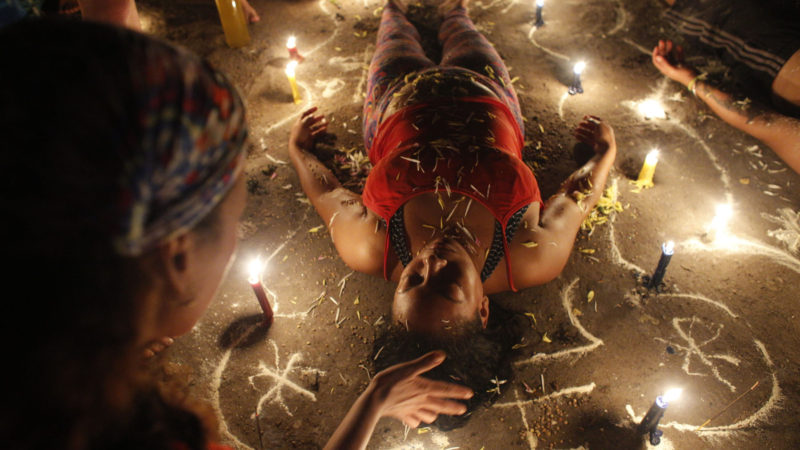 Woman surrounded by candles and designs drawn on the ground with white powder lies with her eyes closed during a spiritual ceremony on Sorte Mountain where followers of indigenous goddess Maria Lionza gather annually in Venezuela's Yaracuy state. Believers often ask for spiritual healing or protection from witchcraft, or thank the goddess for curing an illness. AP Photo/RSS