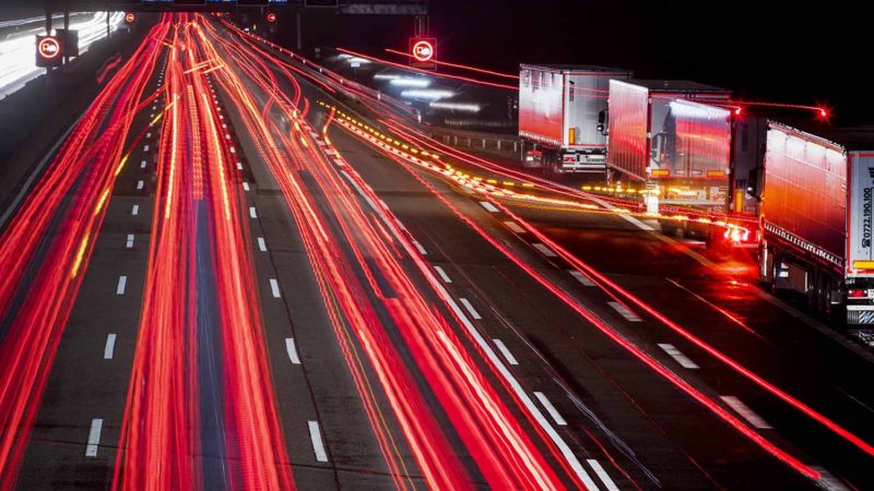 Traffic run near trucks parking overnight at a highway in Frankfurt, Germany, early Friday, Oct. 18, 2019. AP Photo/RSS