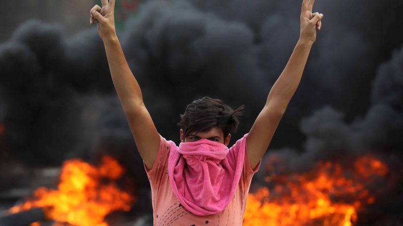An Iraqi protester flashes the v-sign during a demonstration against state corruption, failing public services and unemployment in the Baladiyat district of the capital Baghdad on October 2, 2019. - Iraq's president and the United Nations urged security forces to show restraint after two protesters were killed in clashes with police that other top officials blamed on "infiltrators." AFP/RSS