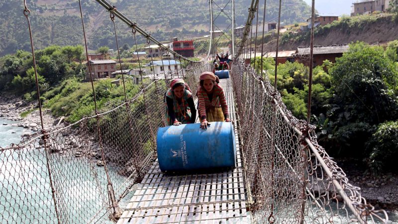 जाजरकोट नलगाड नगरपालिका ७ वगरा र आठविसकोट नगरपालिका राडीको बीचमा रहेको भेरी नदीमा यातायातका साधन गुड्ने पुल नहुँदा झुलुङ्गेपुलबाट ईन्धन भरेका ड्रमहरु डोल्पालान गुडाएर नदी पार गराउँदै । तस्वीर : हेमन्त केसी