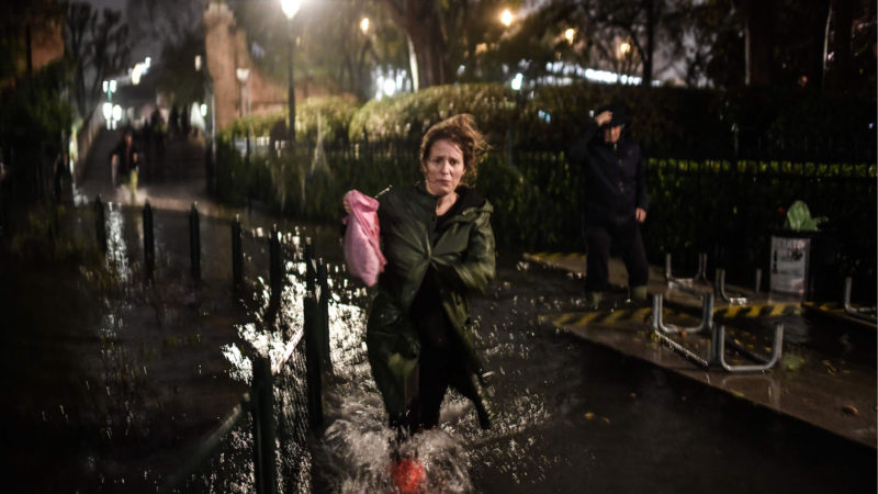 A woman runs across a flooded street during an exceptional "Alta Acqua" high tide water level on November 12, 2019 in Venice. - Powerful rainstorms hit Italy on November 12, with the worst affected areas in the south and Venice. Photo/RSS