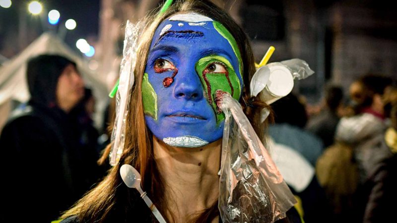 A woman wearing plastic on her hair and with her face painted with earth colors demonstrates during a protest against illegal logging in the forests of Romania gathering aroung 4,000 people downtown Bucharest, Romania, on November 03, 2019. - Around 200 Romanian rangers on October 29, 2019 also protested in Bucharest after two of their colleagues were killed within a month while trying to stop illegal logging. Environmentalists say deforestation is worsening in Romania, with Greenpeace estimating that 20 million cubic metres of wood (700 million cubic feet) are illegally harvested each year. Some 40 environmental groups called on the government "to take action to dismantle organised criminal syndicates in the forestry sector and to strengthen the legislation against illegal logging". (Photo by Daniel MIHAILESCU / AFP)