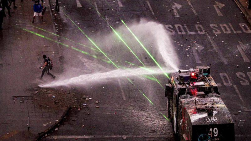 Police water cannon advances on anti-government demonstrators during protest in Santiago, Chile, Monday, Nov. 4, 2019. Thousands of Chileans took to the streets again Monday to demand better social services, some clashing with police, as protesters demanded an end to economic inequality even as the government announced that weeks of demonstrations are hurting the country's economic growth. (AP Photo/Esteban Felix)