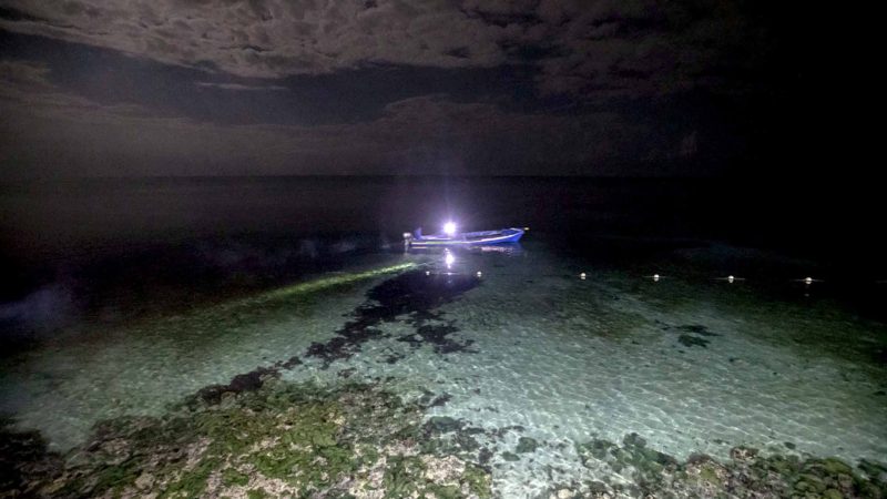 White River Fish Sanctuary wardens Mark Lobban, left, and Donald Anderson patrol the no-take zone for illegal fishermen under moonlight in Ocho Rios, Jamaica, Saturday, Feb. 16, 2019. Spearfishing at night in Jamaica is illegal, especially in the sanctuaries set up to protect the island's endangered coral reefs and replenish fish stocks. (AP Photo/David Goldman)