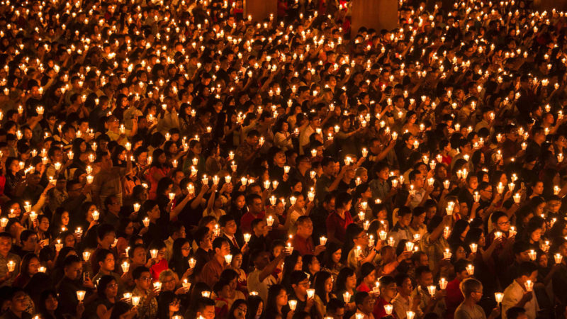 TOPSHOT - Christians rise candles during a Christmas Eve prayer at a church in Surabaya, East Java, on December 24, 2019. (Photo by JUNI KRISWANTO / AFP)