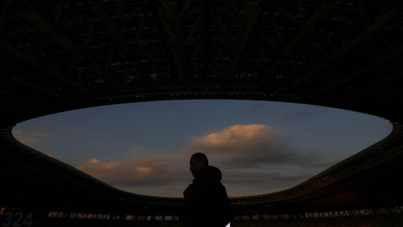 In this Sunday, Dec. 15, 2019, file photo, a man is silhouetted against the sky during a tour at the new National Stadium, in Tokyo. The stadium is officially completed. AP Photo/RSS