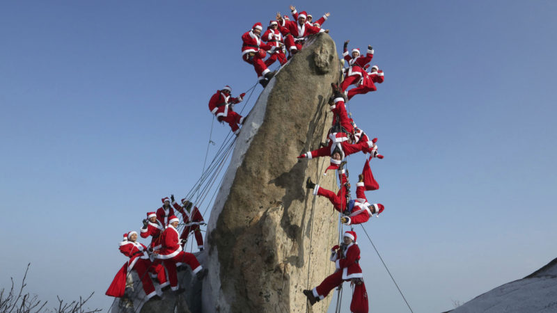 Mountain climbers in Santa Claus outfits pose during an event to hope for safe climbing and to promote Christmas charity on the Buckhan mountain in Seoul, South Korea, Sunday, Dec. 22, 2019. AP Photo/RSS