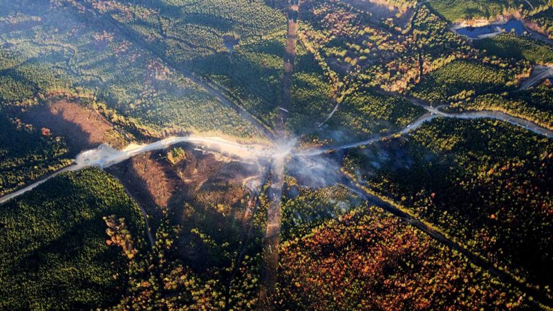 FILE - In this Nov. 1, 2016 file photo, a fog of smoke covers the trees near an explosion of a Colonial Pipeline in Helena, Ala. A federal investigation released Thursday, Dec. 12, 2019, cited inadequate work by an excavation company as the probable cause of a pipeline explosion that killed two people and slowed the flow of fuel to the Eastern Seaboard in 2016. Workers unearthing a Colonial Pipeline Co. pipeline that was carrying thousands of gallons of gasoline near Birmingham failed to plan, coordinate and communicate during the job, according to a report by the National Transportation Safety Board. (AP Photo/Brynn Anderson, File)
