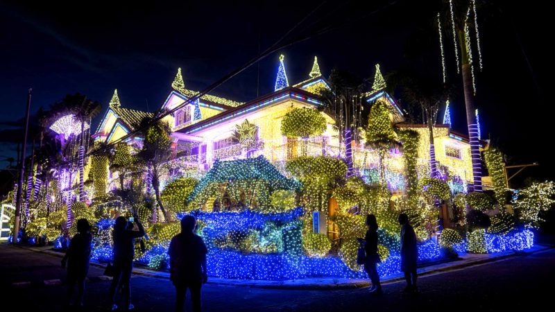 Filipinos enjoy the Christmas decor and holiday lights displayed at the residence of businessman Alexander Cruz in Cainta, Philippines Sunday, Dec. 15, 2019. The whole house is decorated with hundreds of thousands of LED festive lights, and has attracted local and foreign tourists during the holiday season. (AP Photo/Iya Forbes)