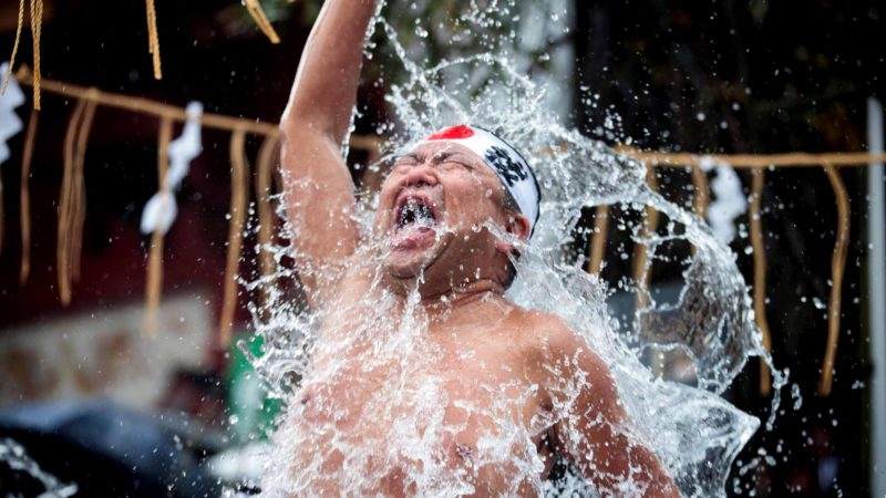A Shinto follower pours cold water over himself to purify body and soul as part of an endurance ritual at Kanda Shrine, known as "Kanda Myojin", in Tokyo on January 18, 2020. (Photo by Behrouz MEHRI / AFP)