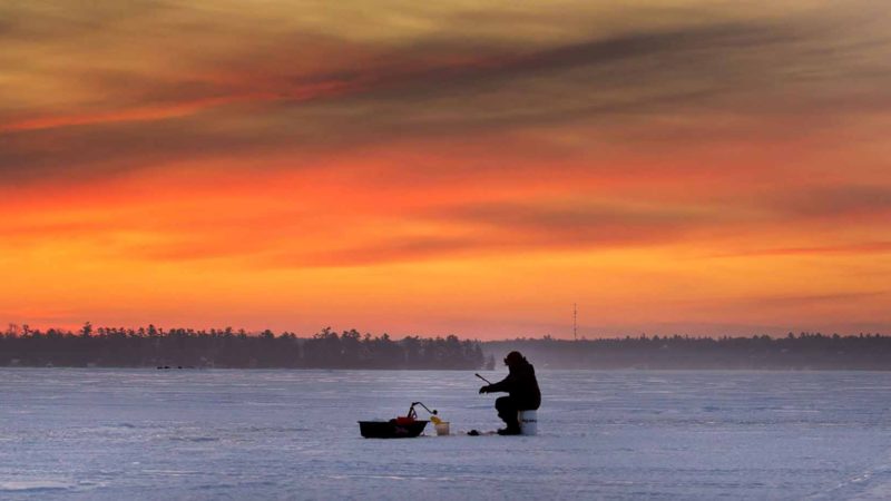 Dawn breaks for ice fisherman on Pigeon Lake in the city of Kawartha Lakes in central Ontario, Canada, on Sunday, Feb. 23, 2020. (Fred Thornhill/The Canadian Press via AP)