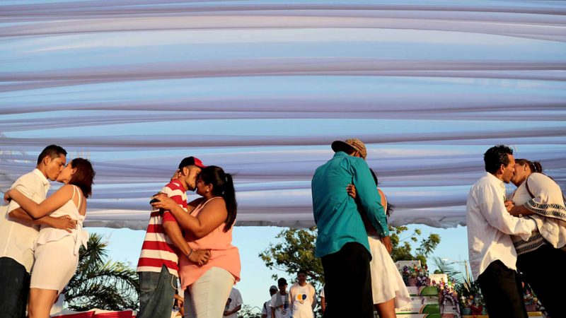 Couples kiss during a "mass wedding" on Valentine's Day, at Paseo Xolotlan Park in Managua on February 14, 2020. - Some 400 Nicaraguan couples with scarce financial resources got married in a free ceremony organized by the Supreme Court and a Sandinista radio station on Valentine's Day. (Photo by INTI OCON / AFP)
