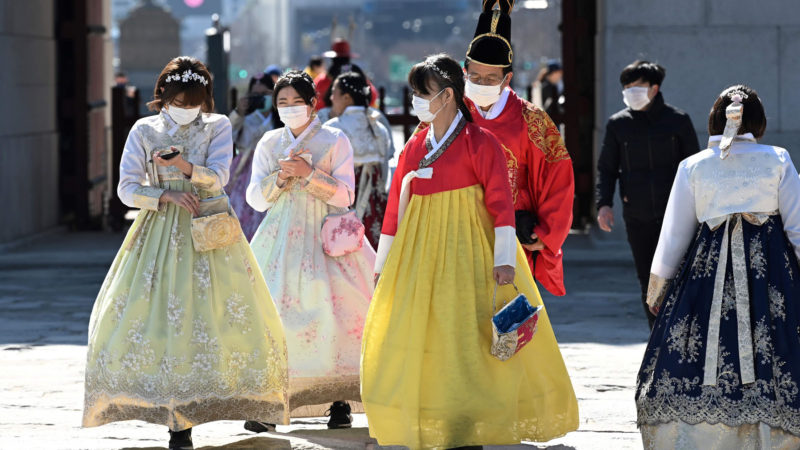 People in traditional Korean hanbok dresses wear face masks as they visit Gyeongbokgung palace in Seoul on February 23, 2020. - South Korea reported two additional deaths from coronavirus and 123 more cases on February 23, with nearly two thirds of the new patients connected to a religious sect. The national toll of 556 cases is now the second-highest outside of China. Photo /RSS