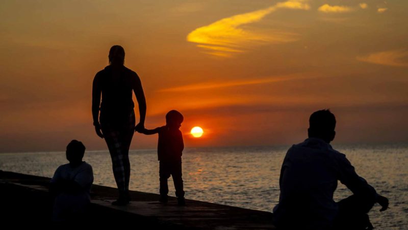 People watch the sunset on the Malecon seawall in Havana, Cuba, Tuesday, Feb. 4, 2020. (AP Photo/Ramon Espinosa)