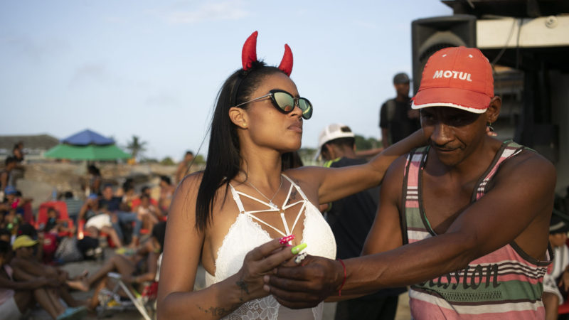 A couple dances at the beach enjoying the Carnival Caribe 2020 in La Guaira,Venezuela, Monday, Feb. 24, 2020. AP Photo/RSS