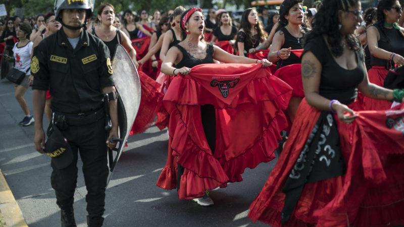 Escorted by riot police, women take part in a protest march to mark the upcoming International Women's Day, in Lima, Peru. Saturday, March 7, 2020. March 8th has been sponsored by the United Nations since 1975 as International Womens Day, celebrating women's achievements and aiming to further their rights. Marches and protests are held across the globe with calls for a more gender-balanced world to mark the day.  (AP Photo/Rodrigo Abd)