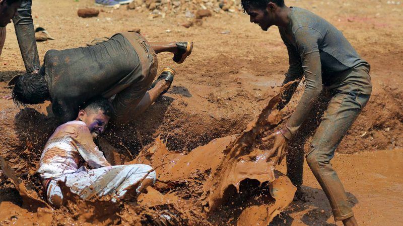 Indians play in mud as they celebrate Holi, the Hindu festival of colors, in Hyderabad, India, Tuesday, March 10, 2020. The festival heralds the arrival of spring. (AP Photo/Mahesh Kumar A.)