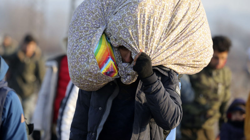 A migrant carrying his belongings walks to reach Pazarakule border gate, Edirne, Turkey, at the Turkish-Greek border on Sunday, March 1, 2020. Turkey's President Recep Tayyip Erdogan said his country's borders with Europe were open Saturday, making good on a longstanding threat to let refugees into the continent as thousands of migrants gathered at the frontier with Greece. AP Photo/RSS