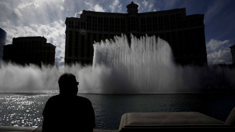 A man watches the fountain show at the Bellagio before its closing due to the coronavirus Monday, March 16, 2020, in Las Vegas. MGM Resorts International and Wynn Resorts will close their Las Vegas properties as of March 17 in light of the coronavirus pandemic. (AP Photo/John Locher)