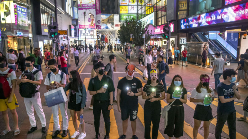 Protestors wearing masks stand along a commercial shopping street in Hong Kong. Last year, face masks were the signature of Hong Kongs protesters, who wore them to protect against tear gas and conceal their identities from authorities. These same masks are now ubiquitous around the world -- worn by people from China and Iran, to Italy and America, seeking to protect against the coronavirus. The vast majority of people recover from the new virus. AP Photo/RSS