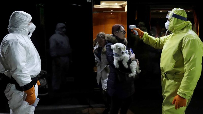 Medical staff members check temperatures of passengers at the border crossing with Germany in Rozvadov, Czech Republic, Friday, March 13, 2020. The Czech Republic is renewing the checks on the borders with Austria and Germany at midnight Friday, and is barring entry to citizens from 15 "risk countries" due to the outbreak of the coronavirus COVID-19. (AP Photo/Petr David Josek)