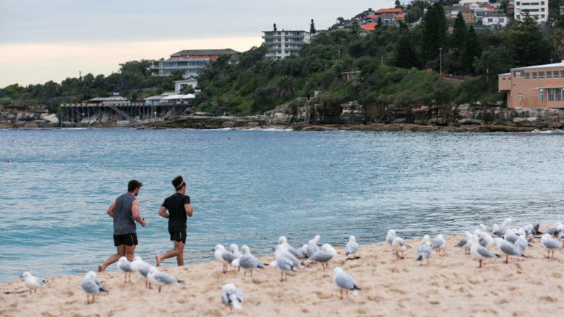 Men run at Coogee Beach in Sydney, Australia on April 20, 2020. Locals hit the water for their first swim in three weeks as Sydney's three beaches are opened for the first time since COVID-19 spread slowed. Photo/RSS