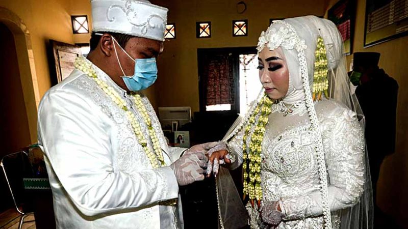 (200405) -- SOUTH TANGERANG, April 5, 2020 (Xinhua) -- A groom puts a ring on the bride's finger on a wedding ceremony during the COVID-19 outbreak at South Tangerang, Indonesia, April 4, 2020. The Indonesian government said on Saturday that the number of confirmed cases of COVID-19 in the country jumped to 2,092, with the death toll climbing to 191. (Photo by Agung Kuncahya B./Xinhua)