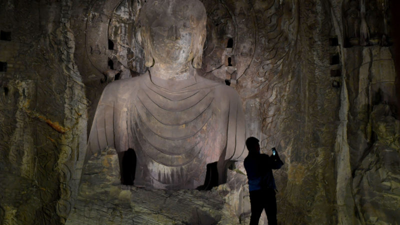 A tourist takes photos at the Longmen Grottoes scenic area during a night tour in Luoyang, central China's Henan Province, April 28, 2020.   The Longmen Grottoes scenic area has introduced night tour programs since April 10 to meet tourist needs. Tourists can join organized night tours via online booking to visit some of the finest Chinese Buddhist art here. (Xinhua/RSS)