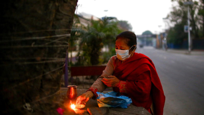  A woman wearing a face mask performs a regular rituals early morning in Kathmandu, Nepal, on April 11, 2020.   Nepal has been enforcing the nationwide lockdown since March 24 which will last until April 15. Photo/RSS