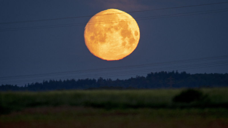 The moon sets behind the hills of the Taunus Mountains near Frankfurt, Germany, early Wednesday, May 6, 2020. (AP Photo/Michael Probst)