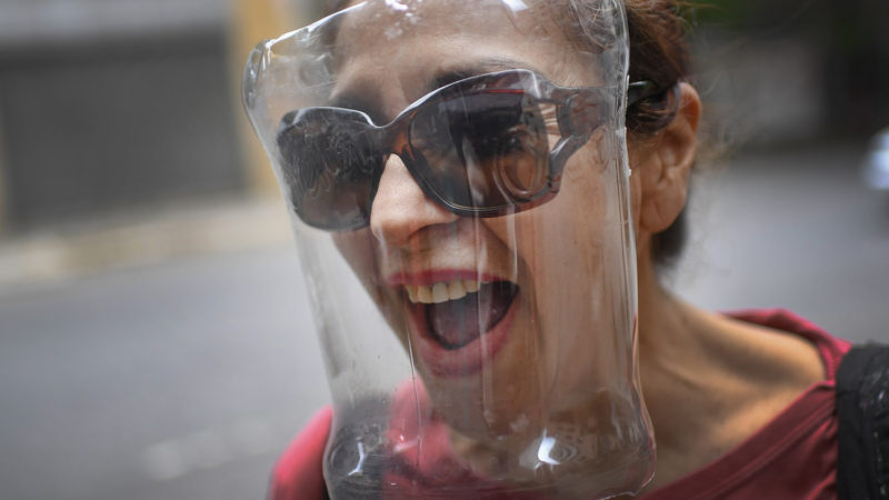 A woman wears a face shield made from a plastic bottle container, amid the spread of the new coronavirus in Caracas, Venezuela, Saturday, April 18, 2020. (AP Photo/RSS)